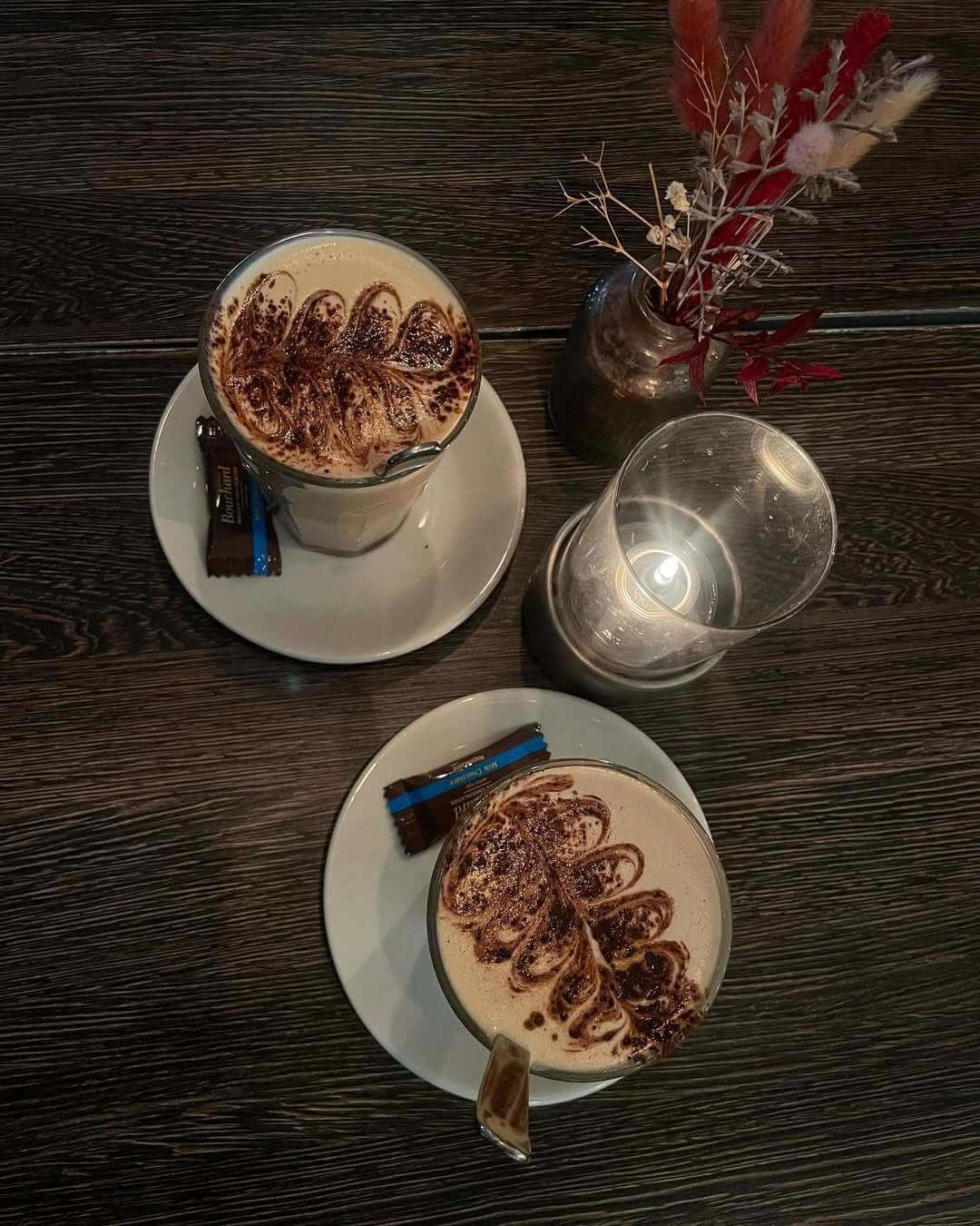 Chai latte med varm mælk, kanel og kakaomønster på toppen serveret på Café Moccador