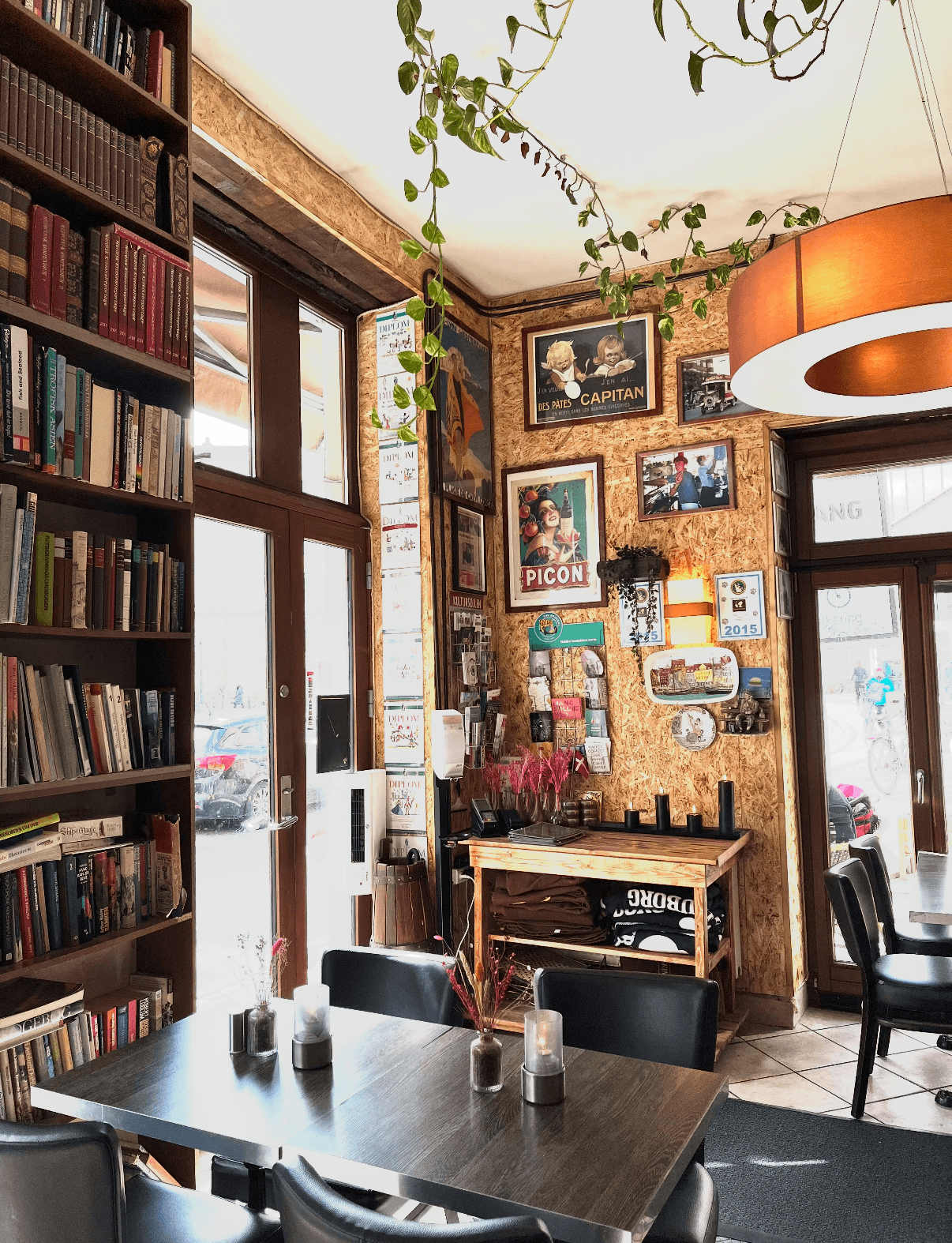 Hyggelig cafeindretning med bogreol og vintage plakater på Café Moccador