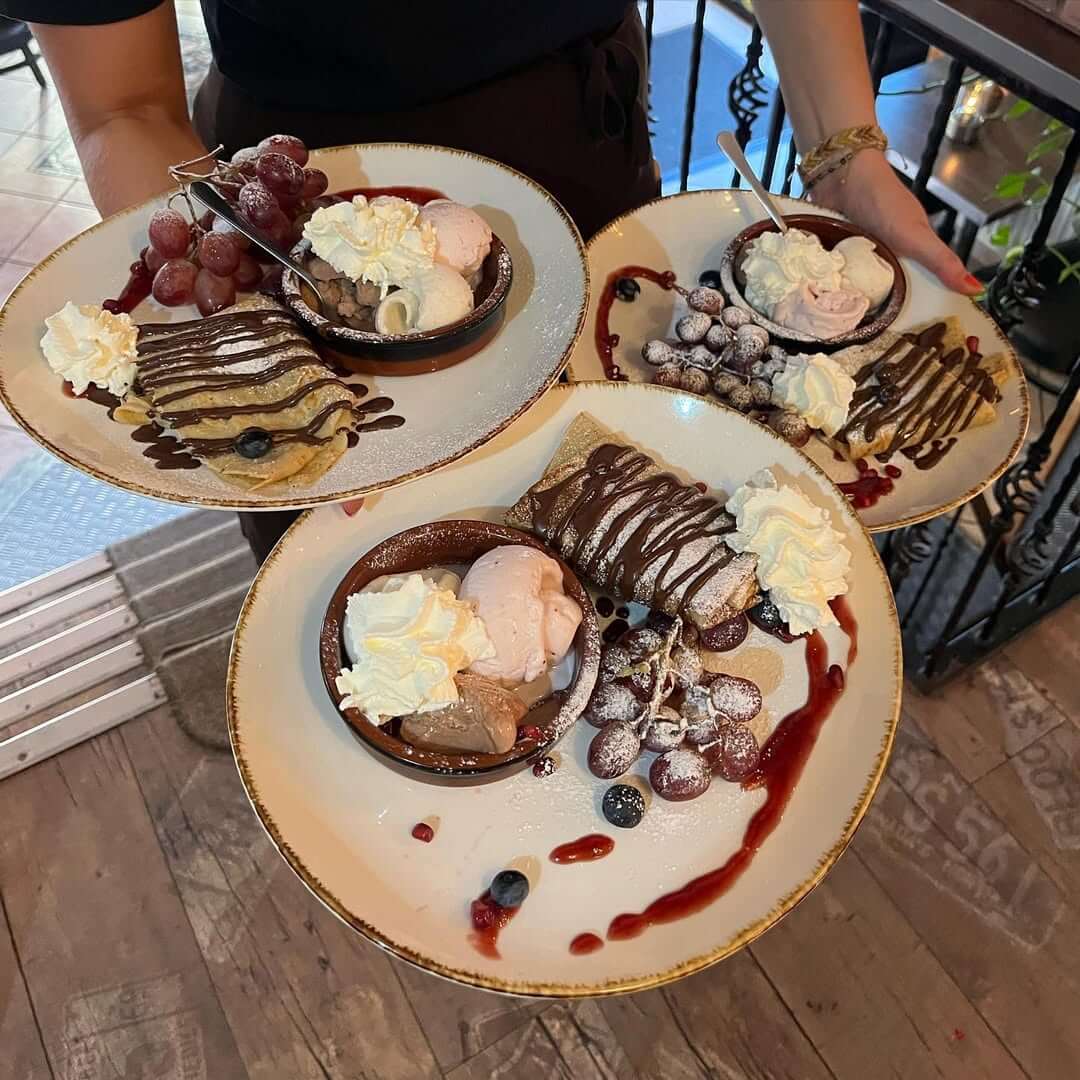 Tre desserttallerkener med crêpes, is og friske bær på Café Moccador